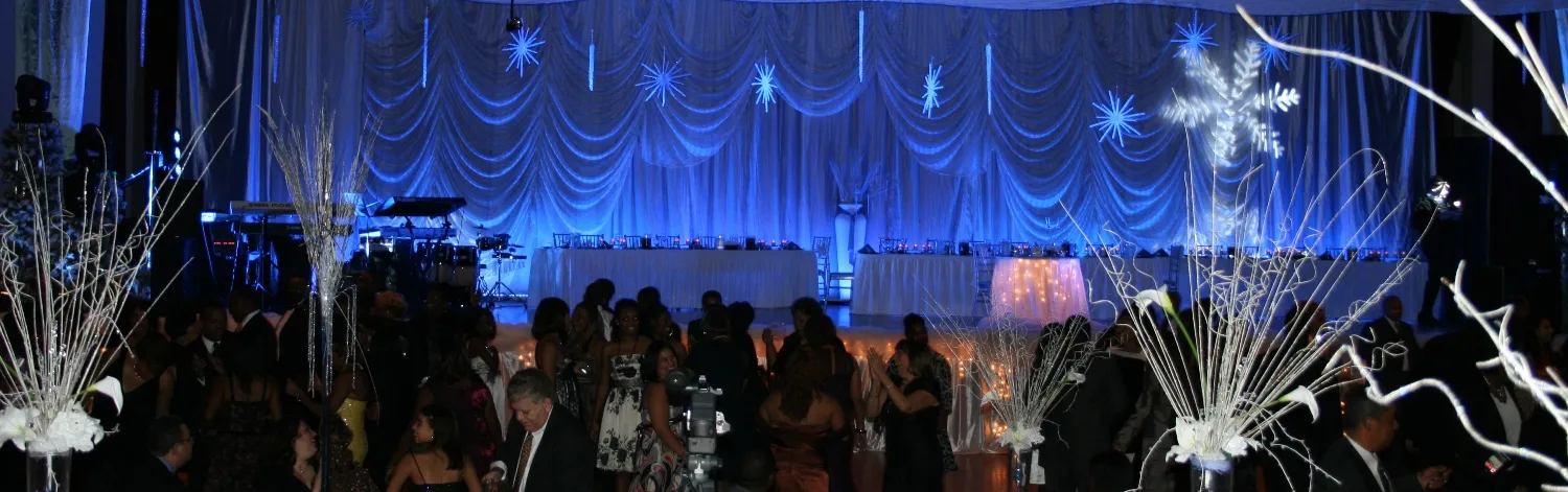 Elegant evening event with blue lighting and guests socializing.
