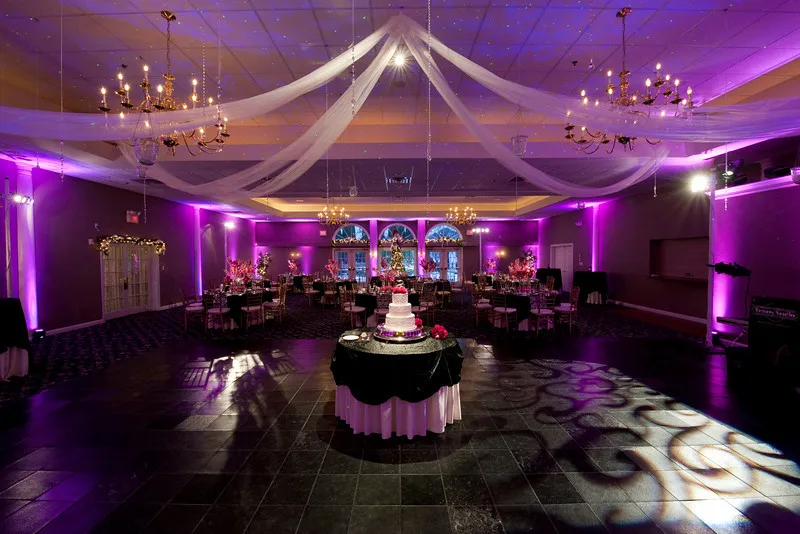 Futuristic roller coaster inside a vibrant, neon-lit indoor amusement park.