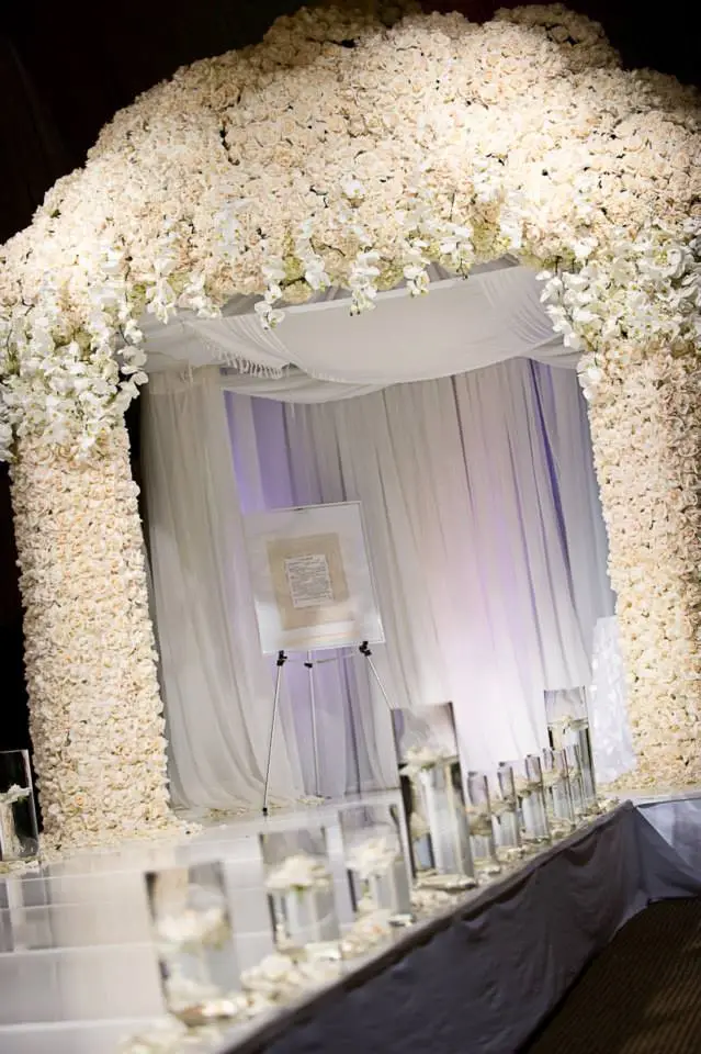 Futuristic roller coaster inside a vibrant, neon-lit indoor amusement park.