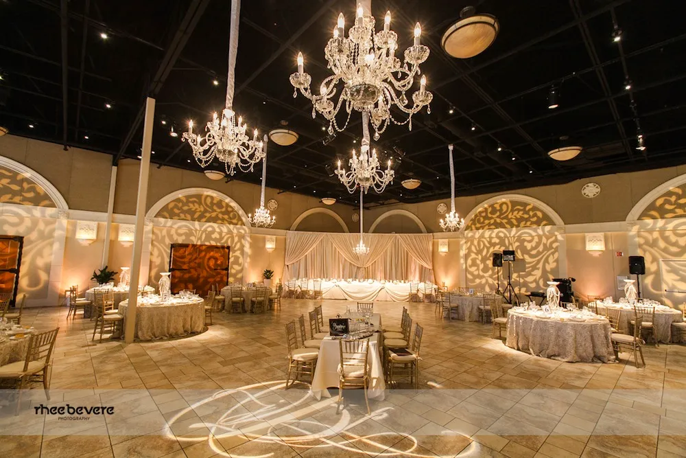 Elegant banquet hall decorated with chandeliers and warm lighting.