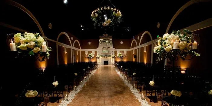 Elegant wedding ceremony setup with chandeliers and floral arrangements.