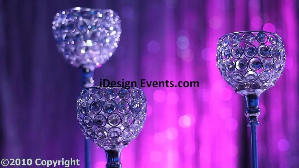 Decorative crystal candle holders against a purple backdrop.