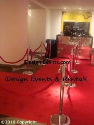 Elegant red carpet event setup with stanchions and clear podiums.