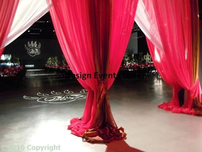 Elegant red fabric drapes tied with a flower at the base.