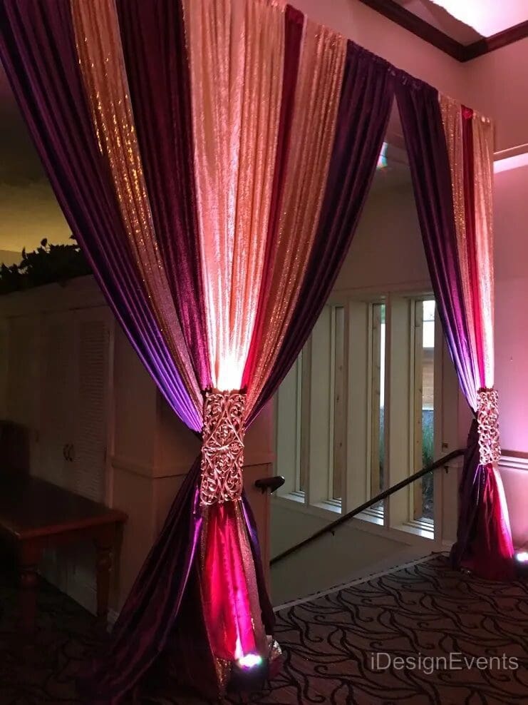 Elegant drapes with glowing pink and purple lighting at night.