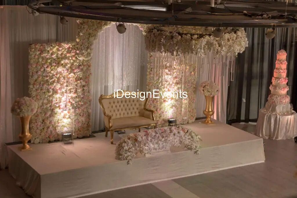 Elegant wedding stage with floral backdrop and vintage sofa.