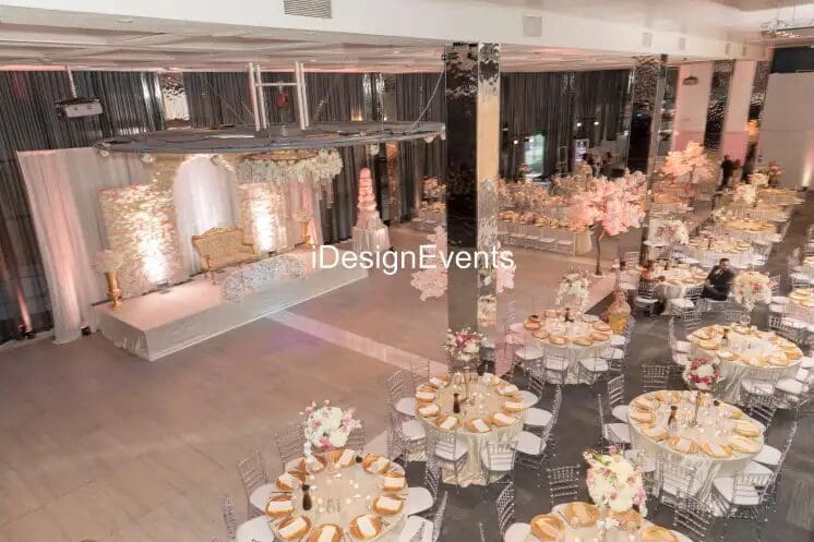 Elegant banquet setup with round tables and floral centerpieces in a softly lit venue.