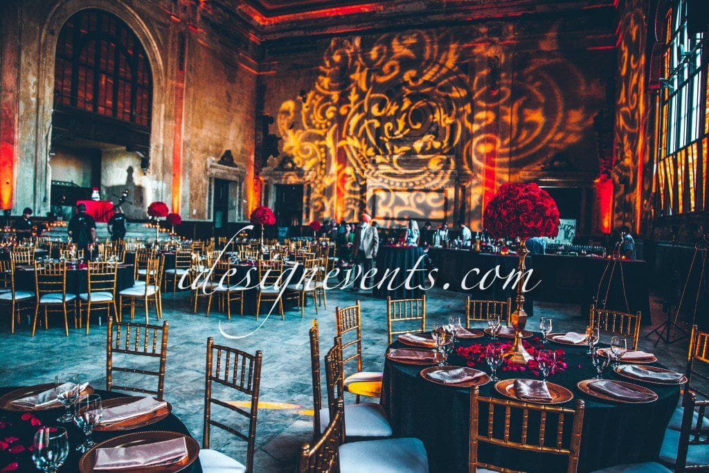Futuristic roller coaster inside a vibrant, neon-lit indoor amusement park.