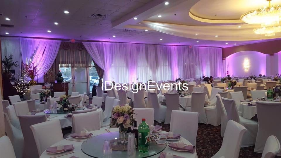 Futuristic roller coaster inside a vibrant, neon-lit indoor amusement park.