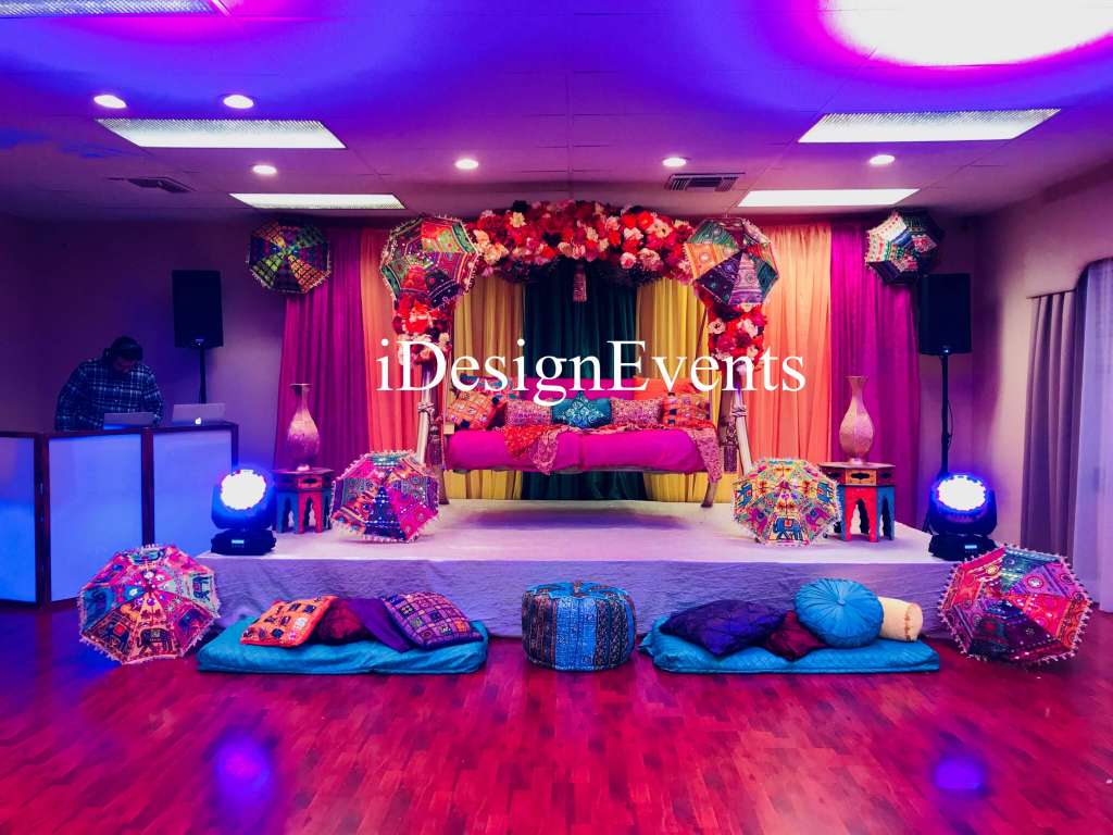 Futuristic roller coaster inside a vibrant, neon-lit indoor amusement park.