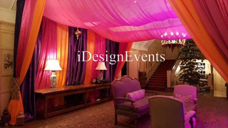 Futuristic roller coaster inside a vibrant, neon-lit indoor amusement park.