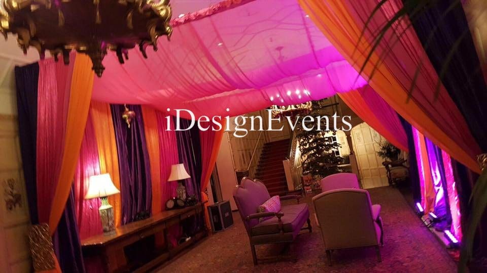 Futuristic roller coaster inside a vibrant, neon-lit indoor amusement park.