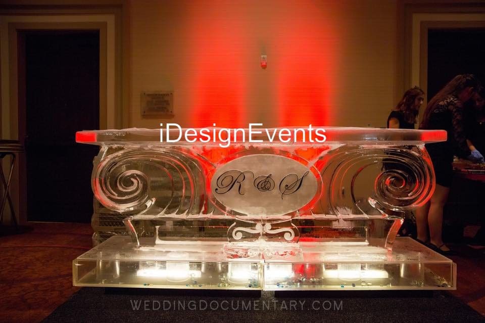 Futuristic roller coaster inside a vibrant, neon-lit indoor amusement park.