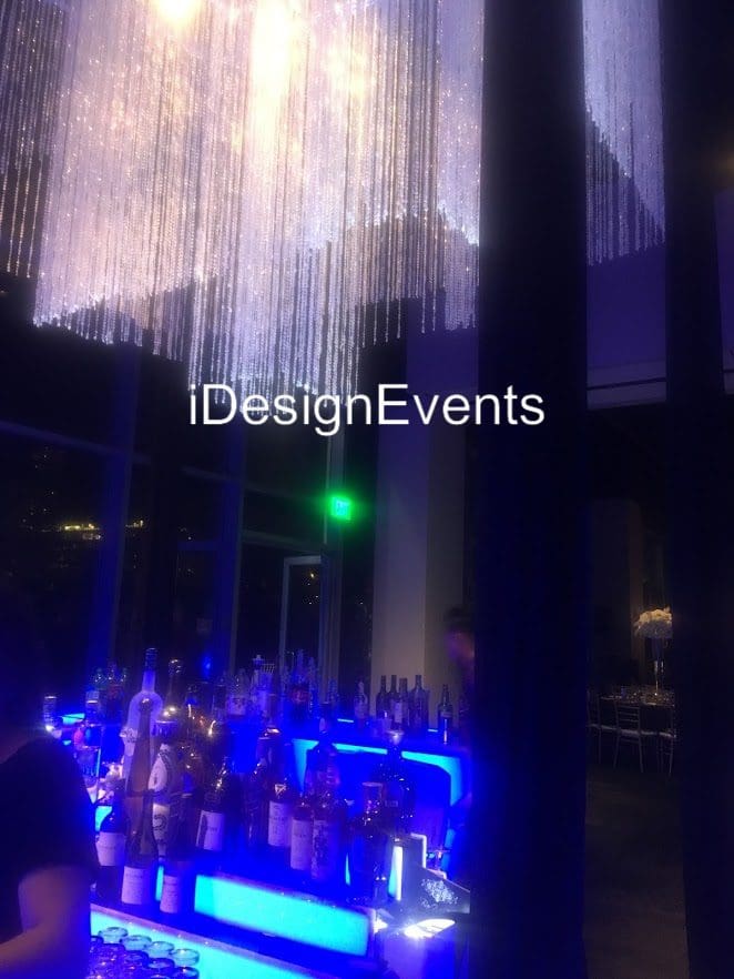 Futuristic roller coaster inside a vibrant, neon-lit indoor amusement park.