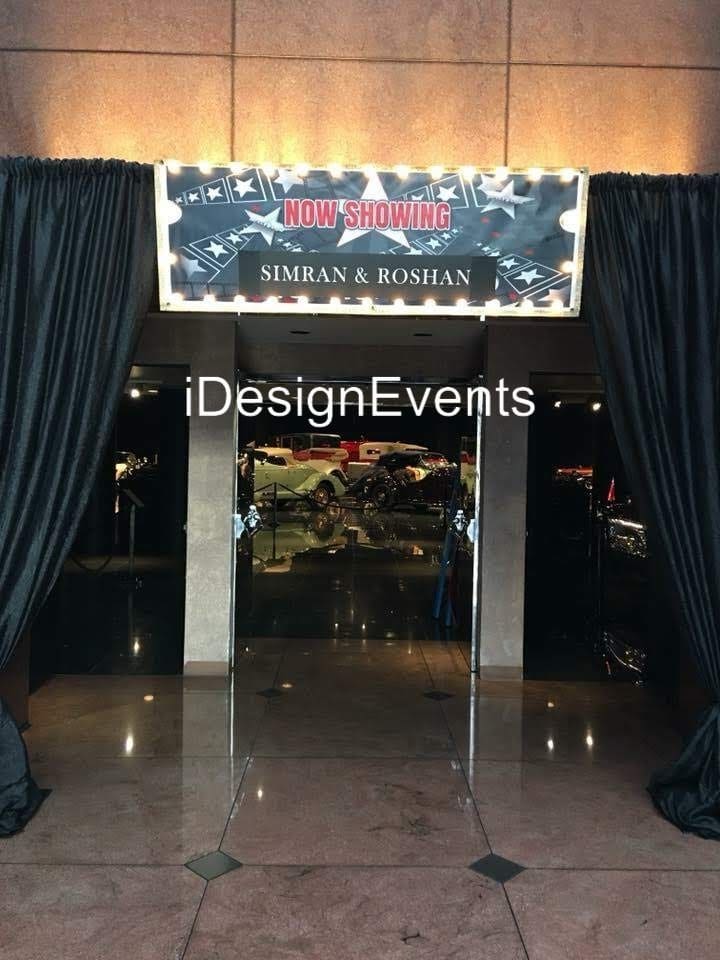 Entrance to a luxury car event with black curtains and a banner.