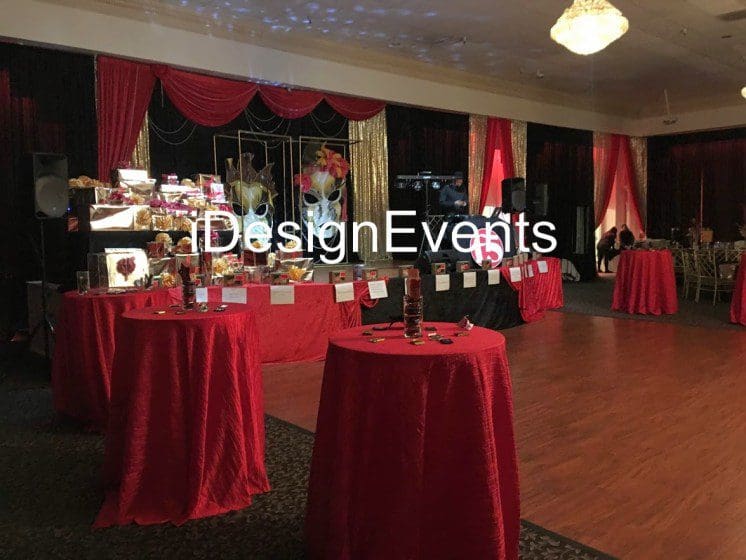 Elegant event setup with red decor and floral arrangements.