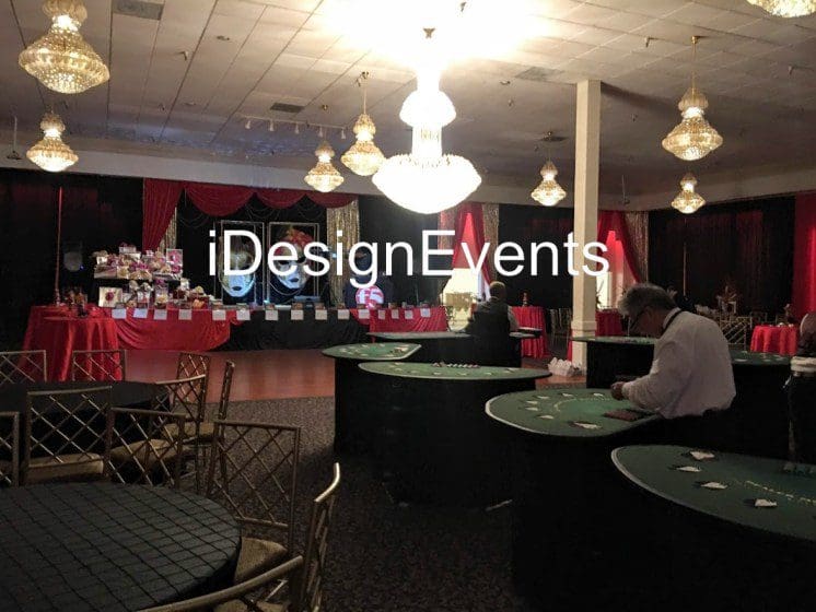 Elegant event setup with red and green lighting and round tables.