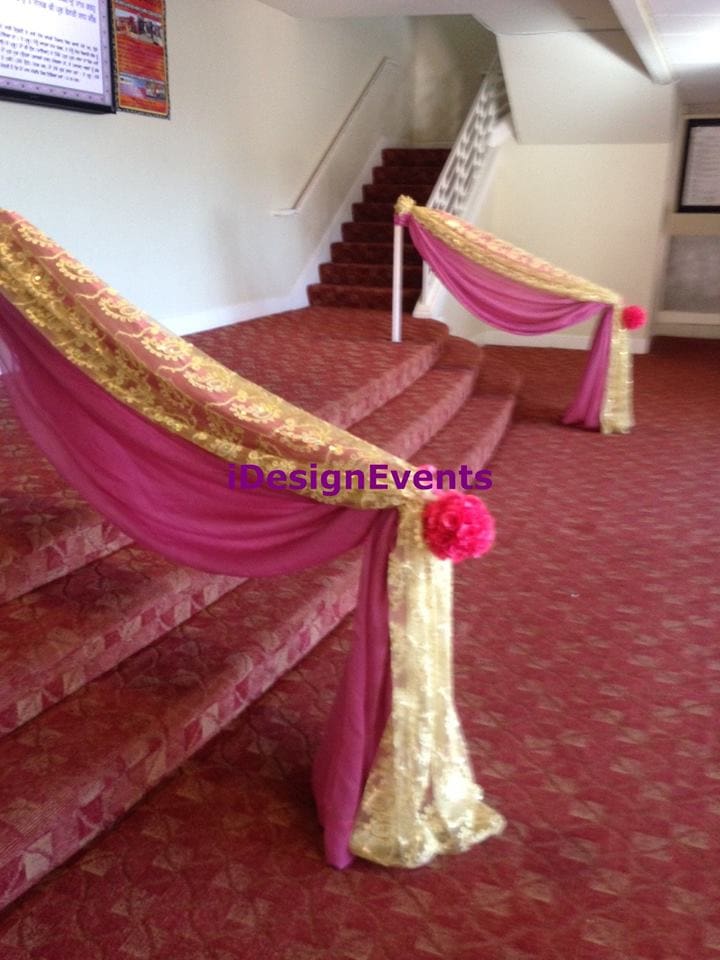 Elegant staircase decorated with pink and gold fabric for an event.
