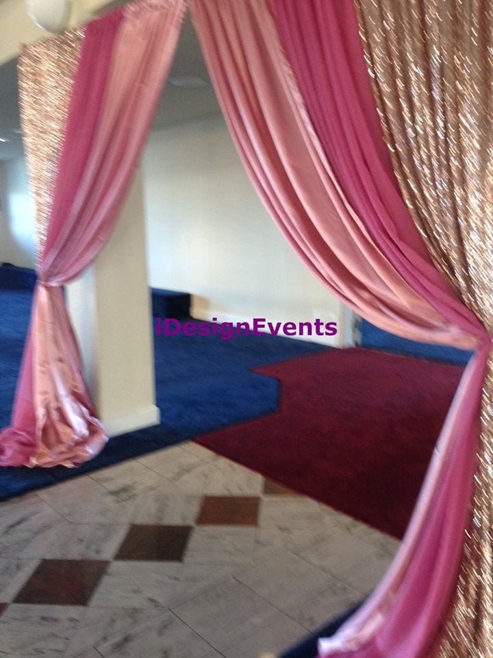 Elegant pink drapes framing an event space with blue and red carpeting.