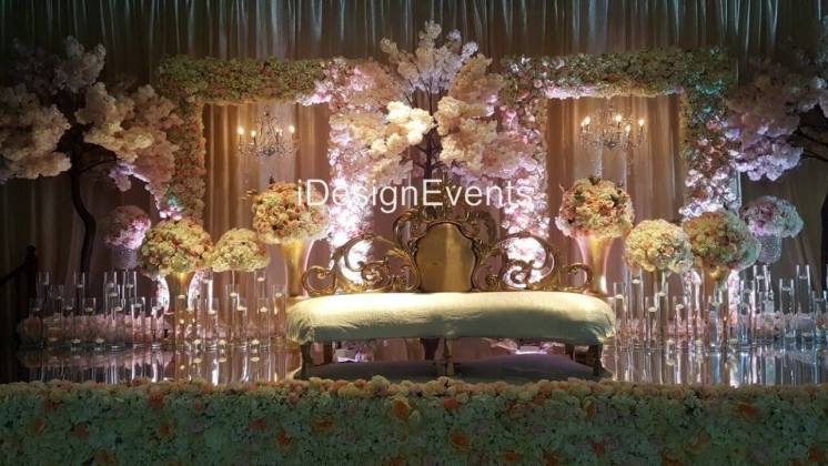 Elegant wedding stage with floral and golden decor.