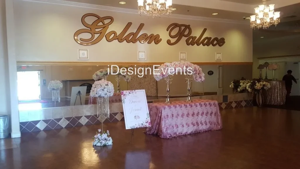 Elegant event setup at Golden Palace with floral decorations and a pink tufted table.