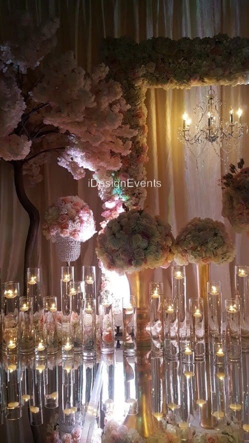 Elegant floral centerpiece with candles and chandeliers at a formal event.
