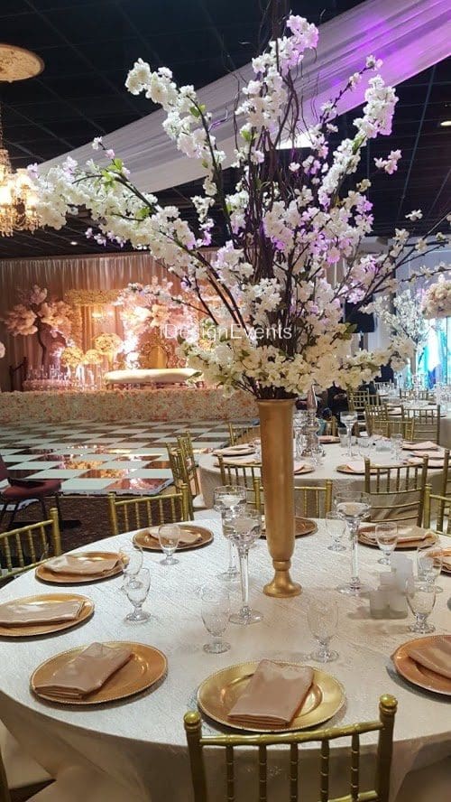 Elegant banquet setup with floral centerpiece and stage lighting.
