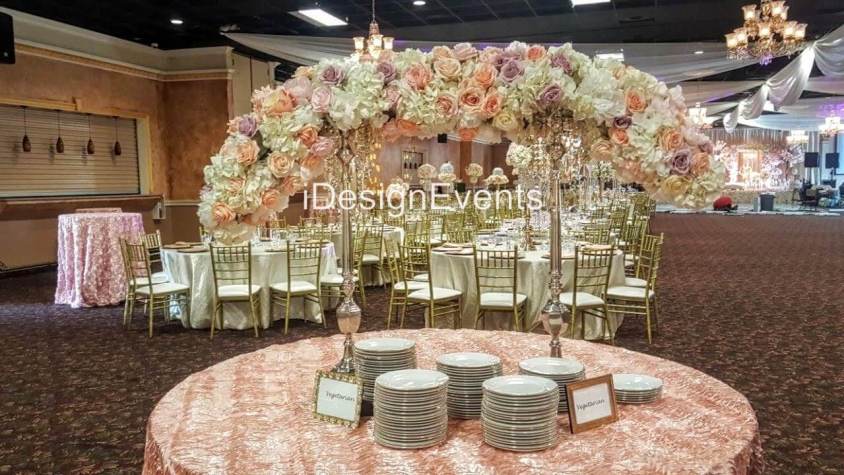 Elegant floral arch with soft pink and white flowers at a wedding venue.