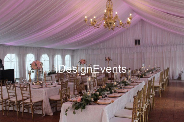 Elegant wedding reception setup with floral decorations and chandeliers.