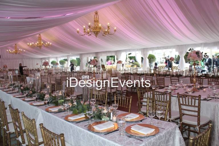 Elegant wedding reception setup with floral centerpieces and draped ceiling.