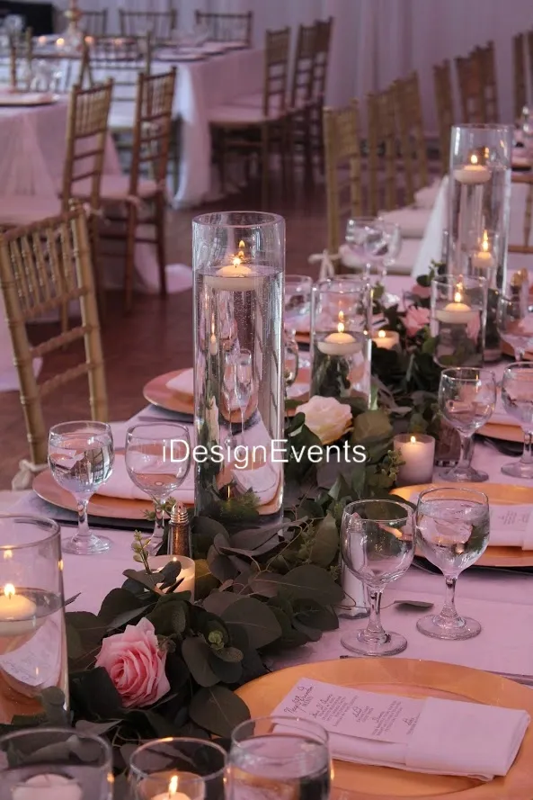 Elegant wedding table setting with candles and greenery.