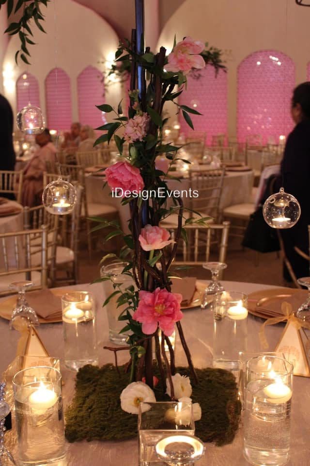 Elegant floral centerpiece with candles on a banquet table.