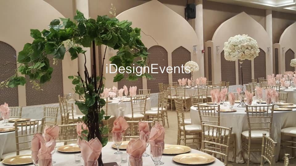 Elegant banquet hall set for a formal event with floral centerpieces and gold chairs.