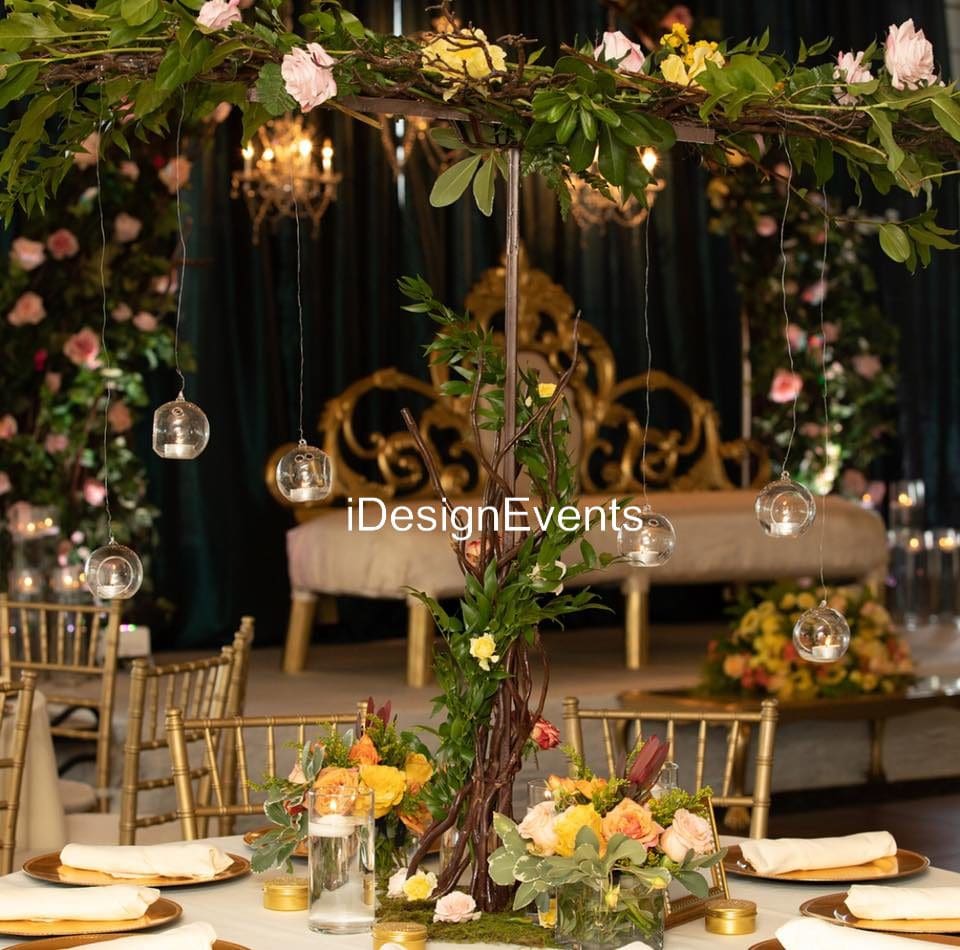 Elegant wedding centerpiece with roses and greenery on a decorated table.