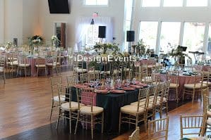 Elegant wedding reception setup with round tables and gold chairs.