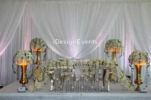 Elegant wedding stage setup with white and yellow floral decorations and draped fabric.