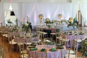 Elegant wedding reception setup with floral centerpieces and gold chairs.