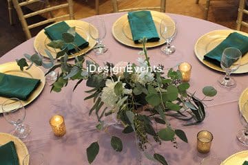 Elegant table setting with greenery and candles for a formal event.