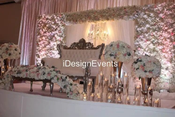Elegant wedding cake table adorned with floral arrangements and candles.