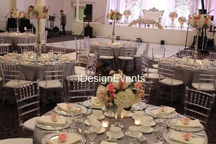 Elegant wedding reception setup with floral centerpieces and white decor.