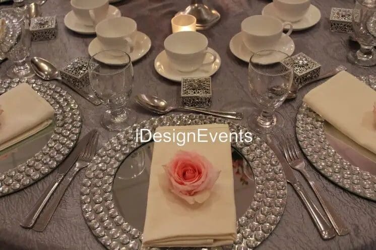 Elegant table setting with rose and crystal charger plates.
