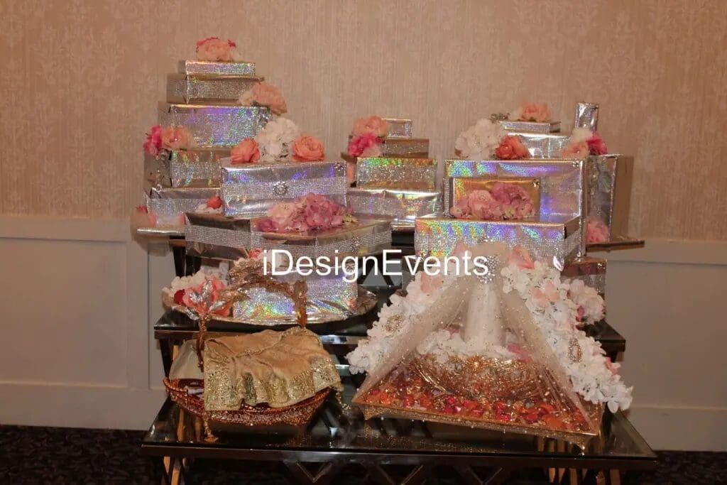 Elegant wedding gift display with flowers and decorative trays.