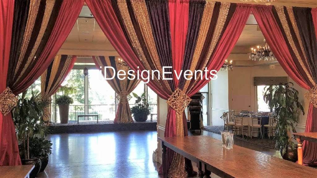 Elegant draped curtains in red and brown tones framing a cozy, stylish space.