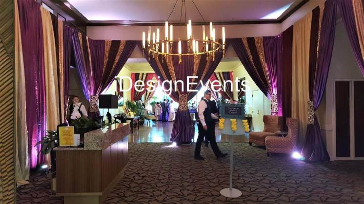 Elegant event venue with chandelier and purple lighting.
