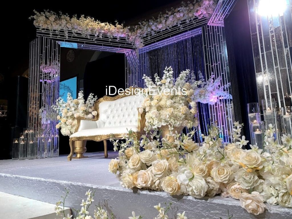 Elegant wedding stage with luxurious floral and golden decor.