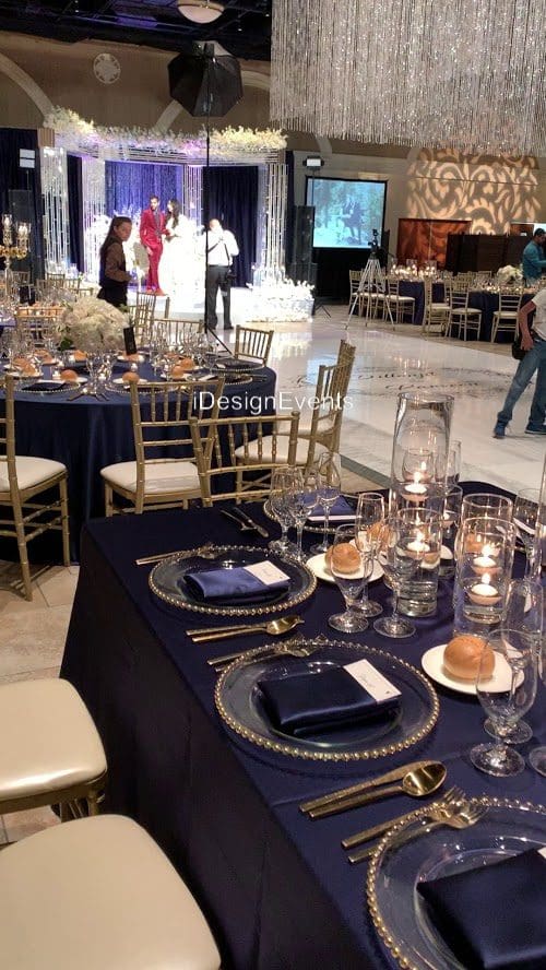 Elegant table setting with black and gold accents and candlelight.
