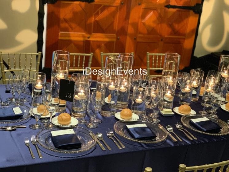 Elegant dinner table set with candles and fine dining ware.