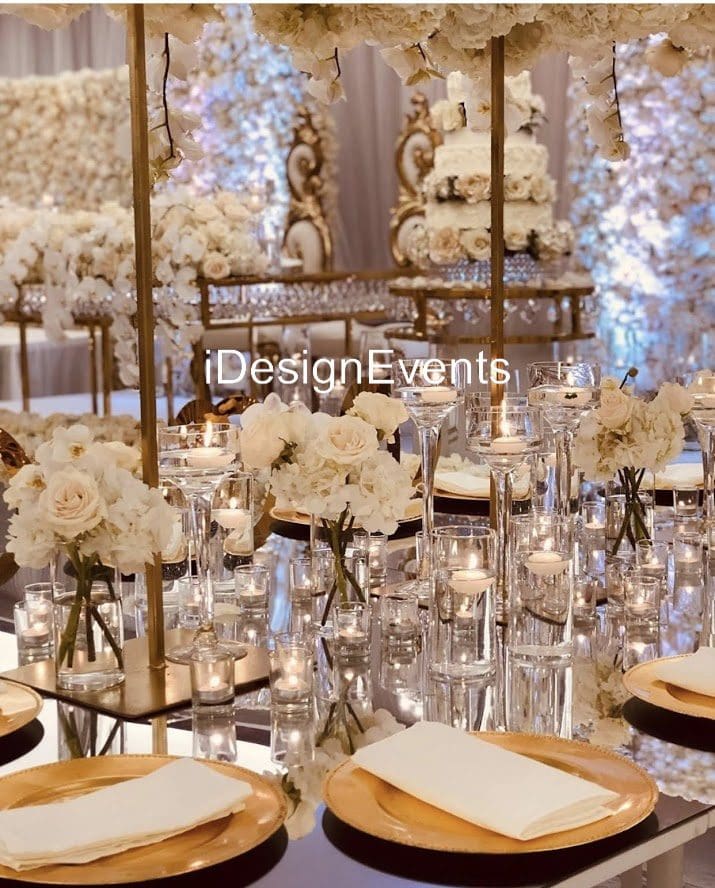 Elegant wedding table setup with white floral arrangements and candlelight.