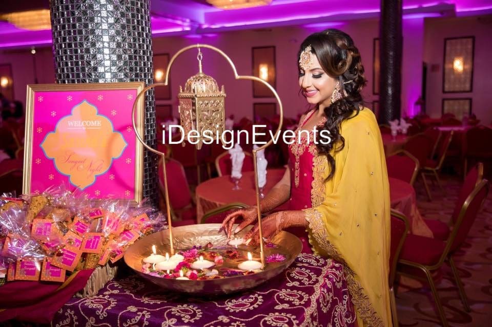 Woman lighting candles at an elegant event with purple lighting.