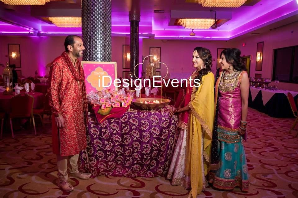 Guests enjoying a festive Indian event with vibrant attire and decor.
